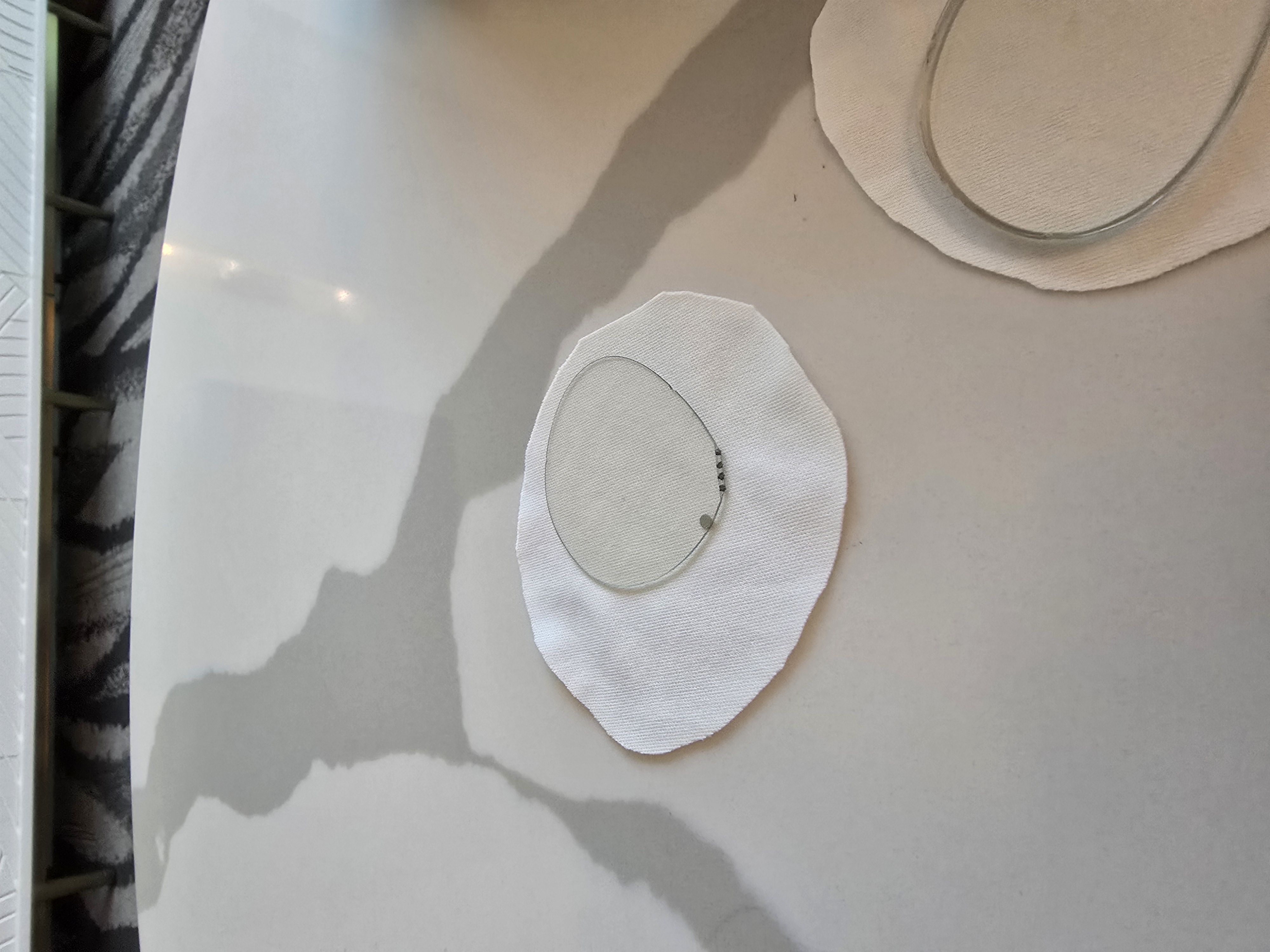 A new type of glasses lens developed by IXI can automatically change its focus. Along one edge, three points may appear: electrical contact points that connect to the frames of the glasses. 