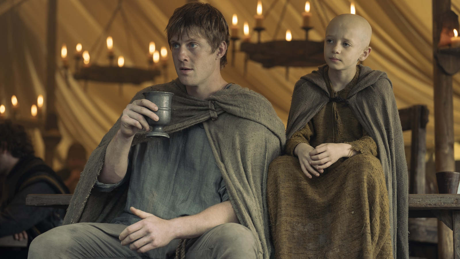 Duncan holding a cup as 'Egg' sits next to him in season 1 of A Knight of the Seven Kingdoms