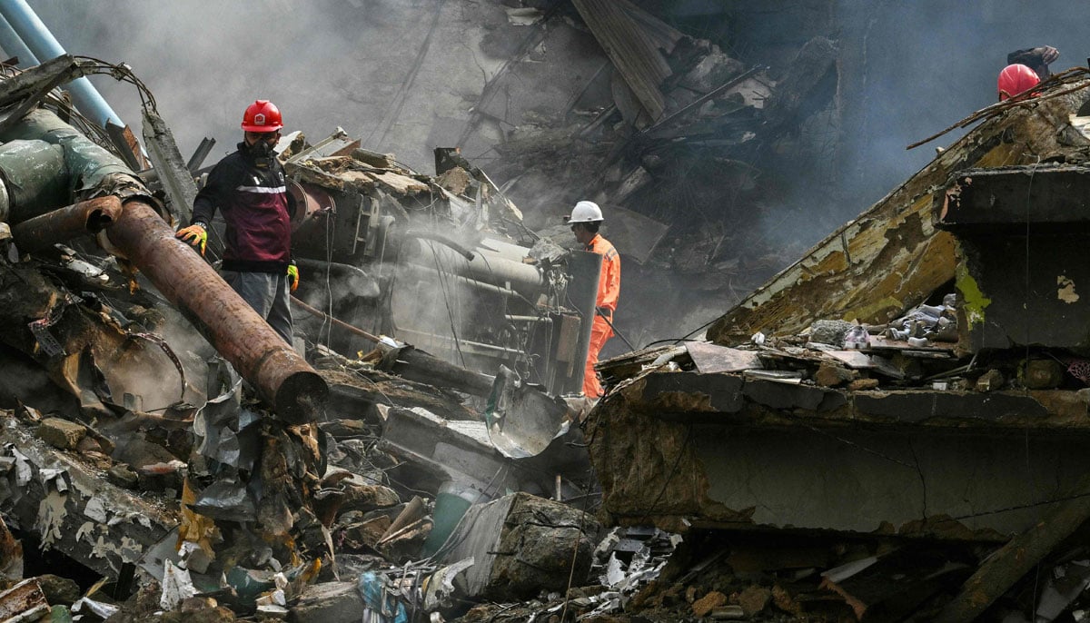 Rescuers search through the rubble after a major fire at a shopping mall in Karachi on January 19, 2026. — AFP