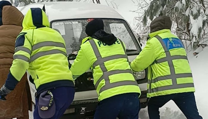 Rescue officer trying to remove a vehicle stuck in a snow-covered area after heavy snowfall of the winter season, which further lowers the temperature below minus degrees Celsius, in Galiyat area of ​​Abbottabad on Friday, January 23, 2026. - PPI