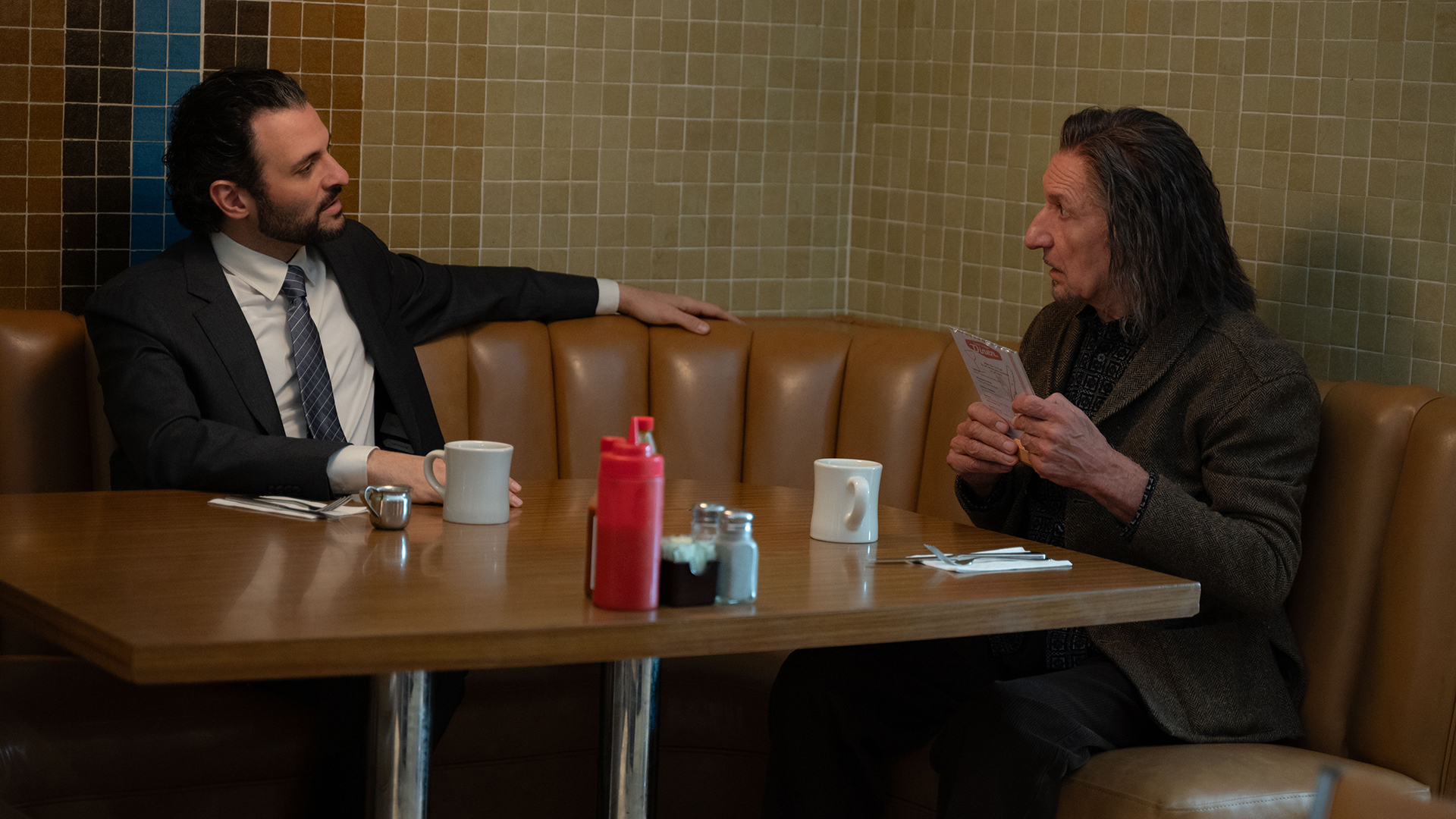 DoDC Agent Cleary sitting at a diner table with Trevor Slattery in Marvel's Wonder Man