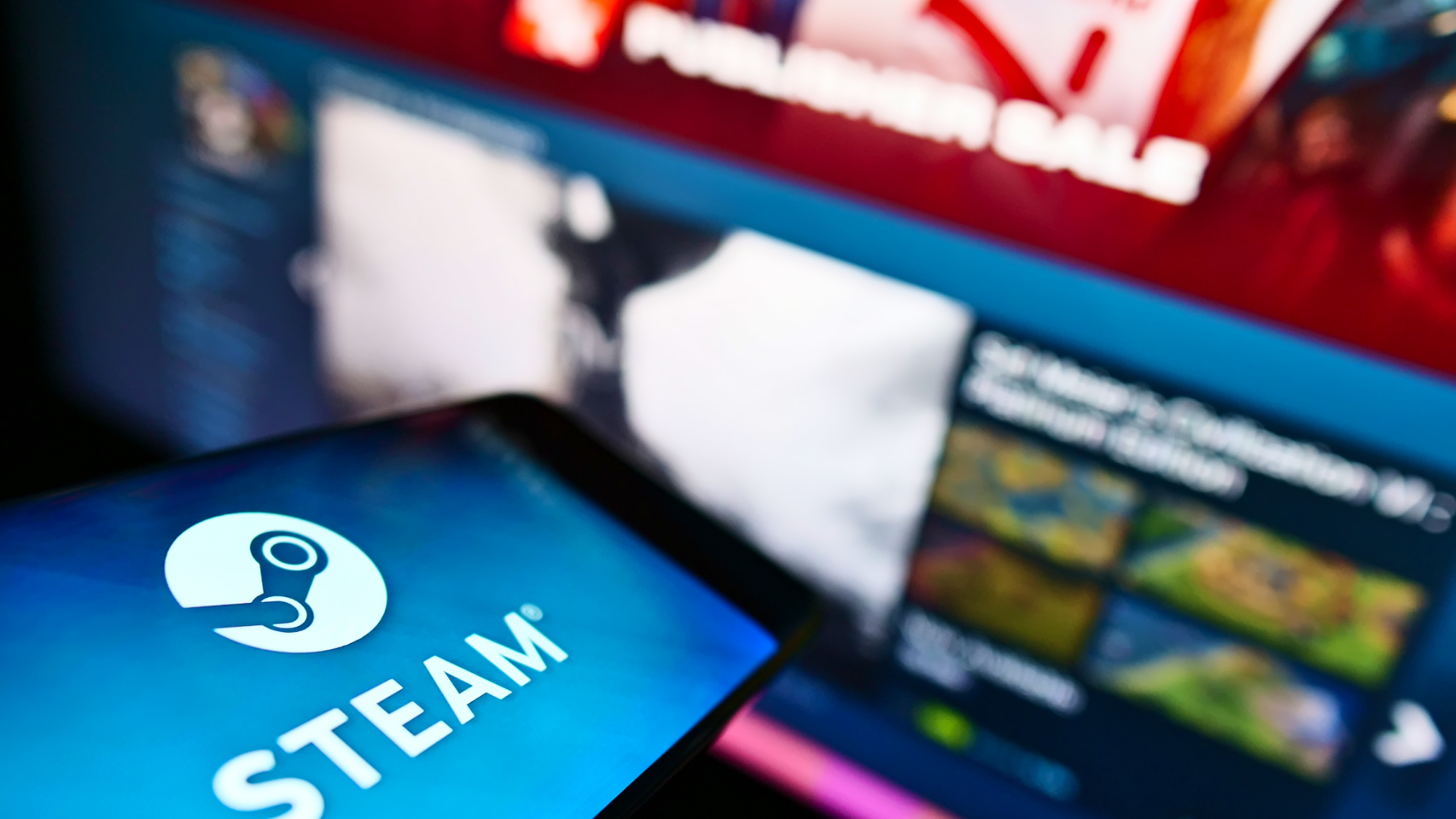 Mobile phone with the logo of the Steam video game distribution platform operated by Valve on the screen in front of the web page