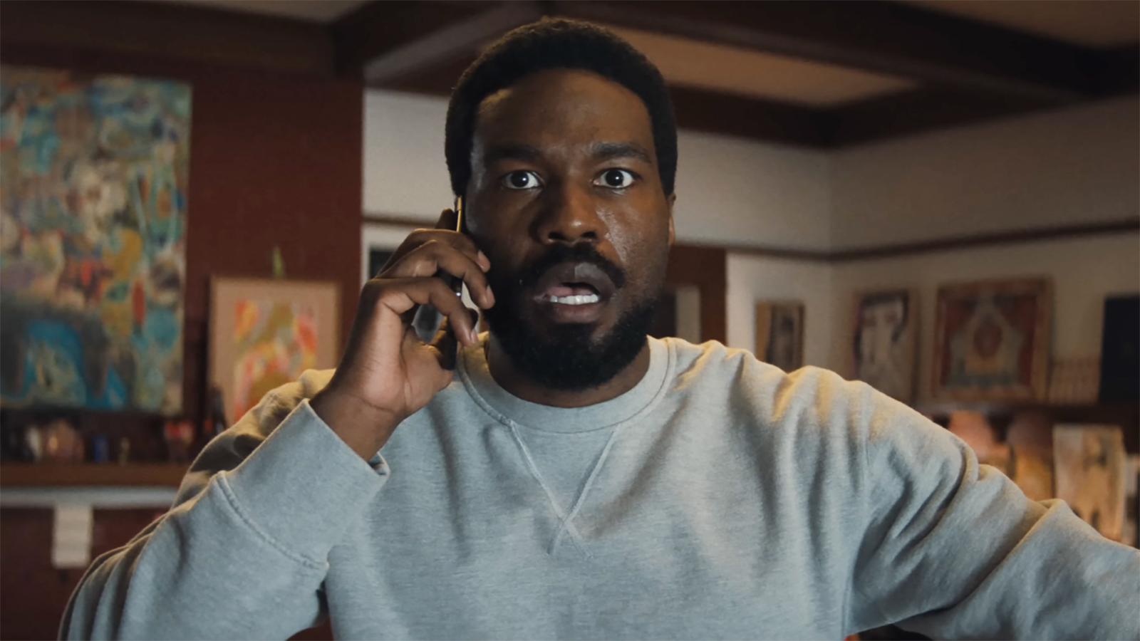 Simon Williams appears surprised while listening to someone during a mobile phone call in Marvel's Wonder Man.