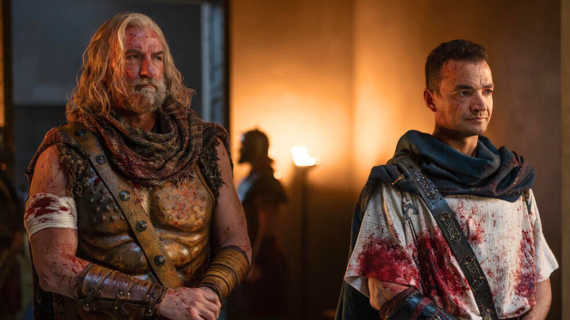Korris and Ashur stand side by side covered in blood.