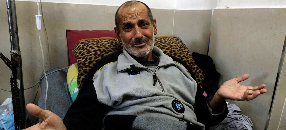 Mundhir Abu Foul, a cancer patient in Gaza, sitting on a hospital bed with his hands open, appears to speak or make a gesture.