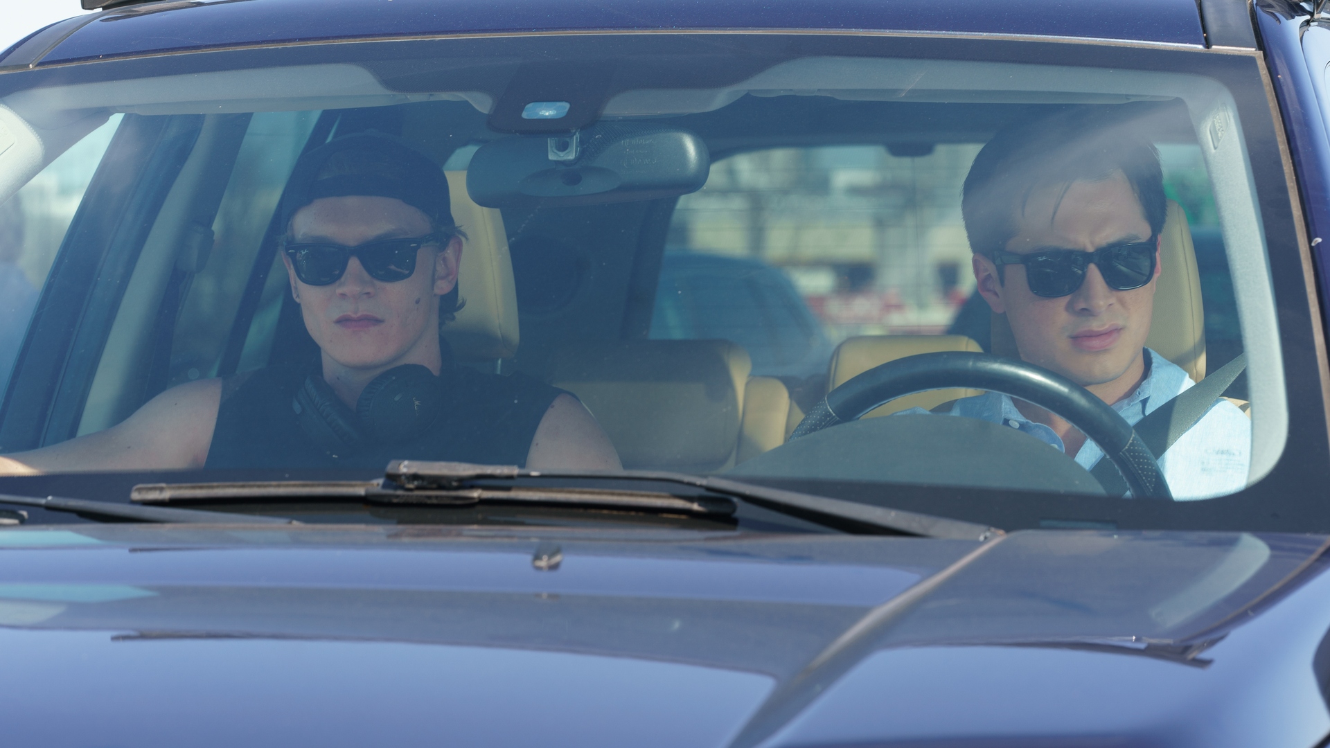 Ilya and Shane drive a car with sunglasses in Heated Rivalry