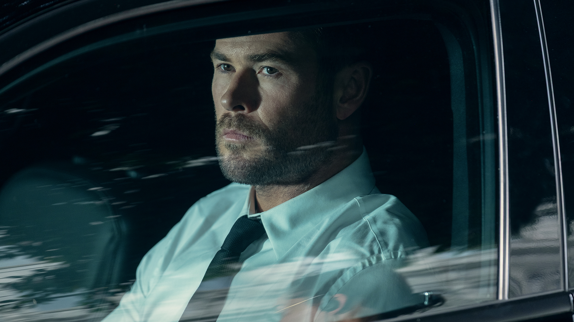 Chris Hemsworth's Davis looking out the driver's side car window on Crime 101