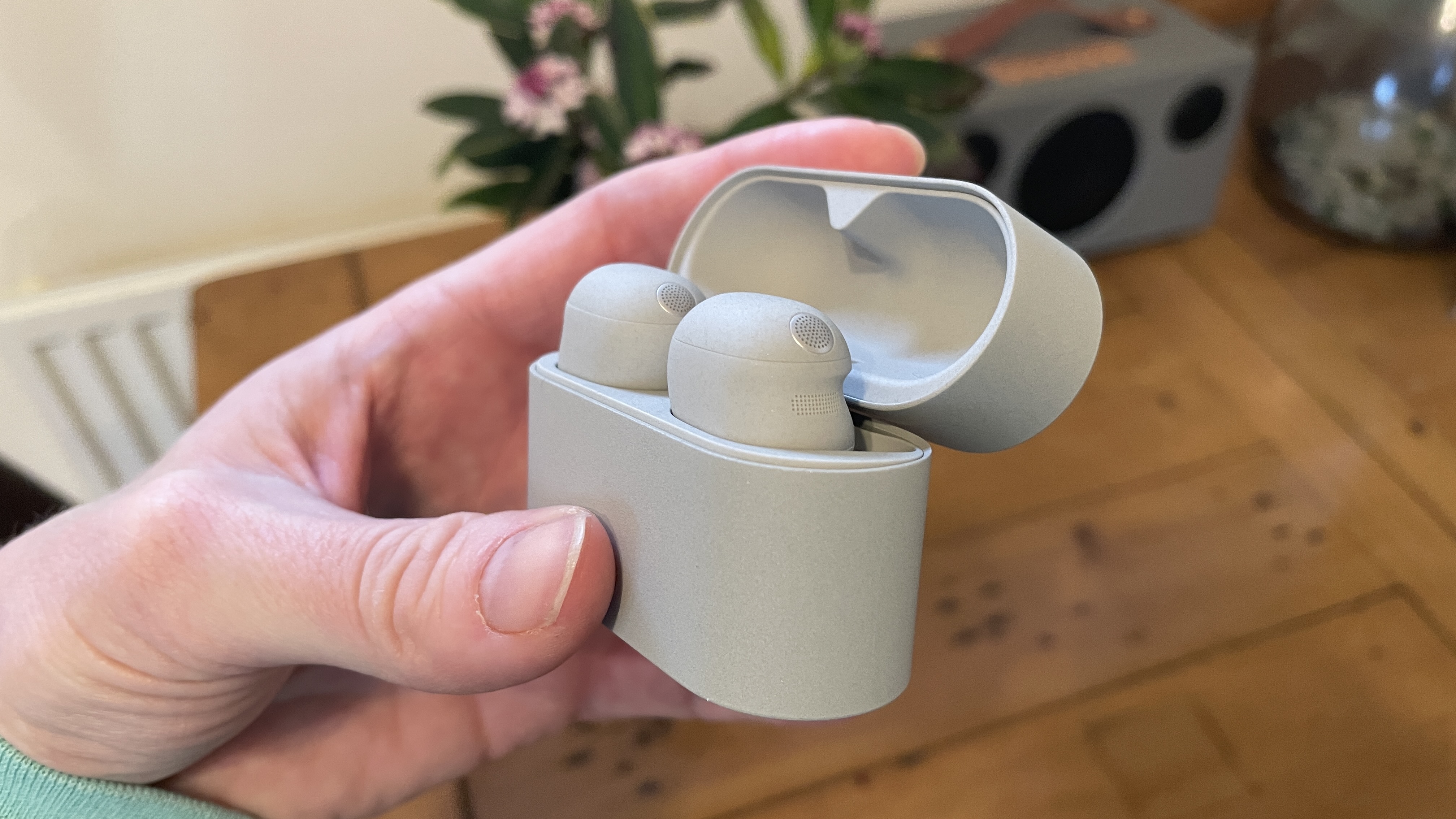 Sony WF-1000XM6 headphones next to the previous generation. WF-1000XM5 and WF-C710N, on colorful table