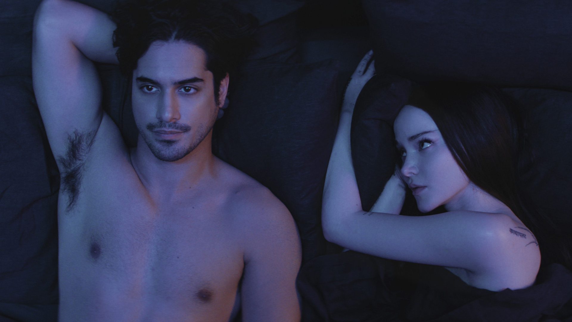 Oliver lying on his back and Ciara lying on her side watching him in bed in 56 Days