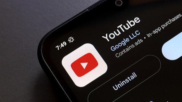 The YouTube application logo appears on the screen of a smartphone