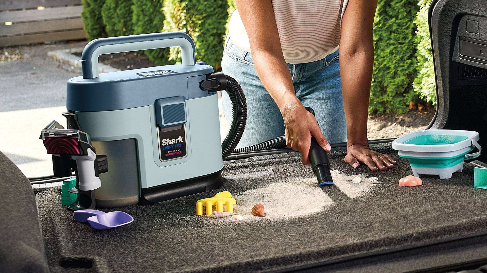 Shark EveryMess 3-in-1 cleaner is used to clean sand from a car trunk