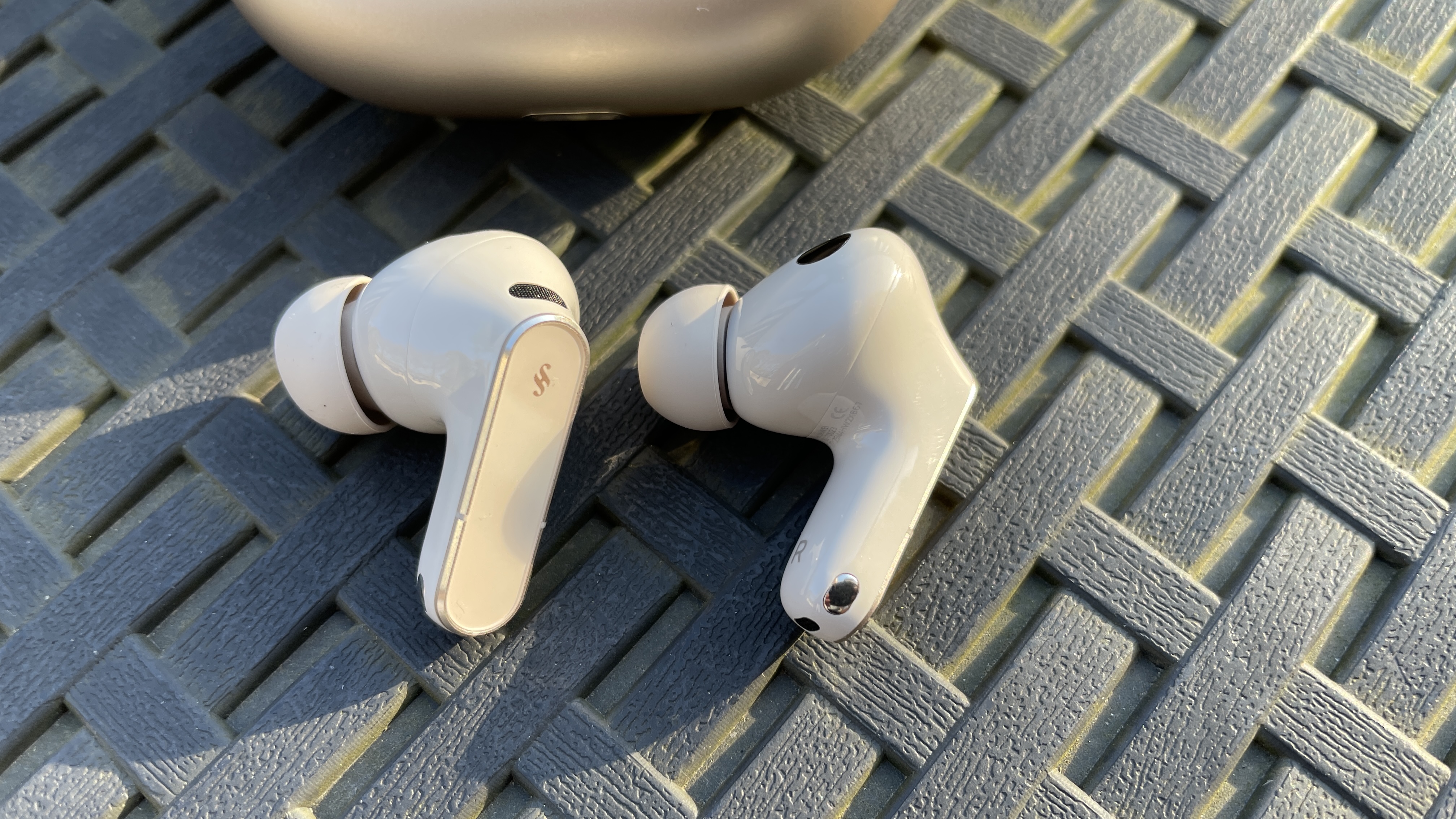 Huawei FreeBuds Pro 5 outside, near some daffodils, in the afternoon sun