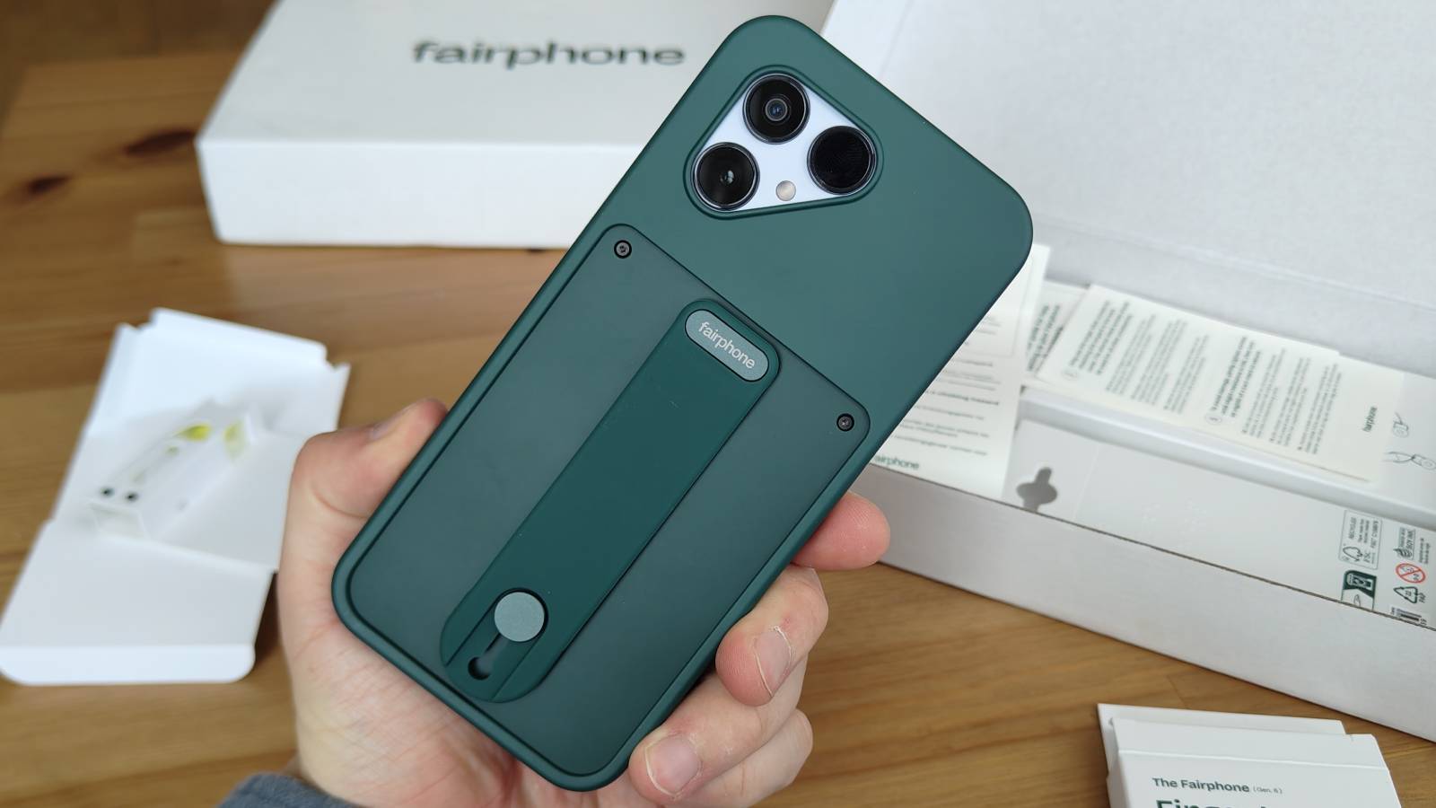The Fairphone 6 with its case and attached finger grip.