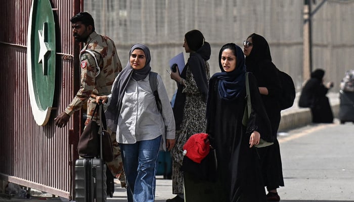 Pakistani nationals cross the Taftan border after returning from Iran, in Balochistan province, on March 2, 2026, amid ongoing US and Israeli attacks on Iran. — AFP
