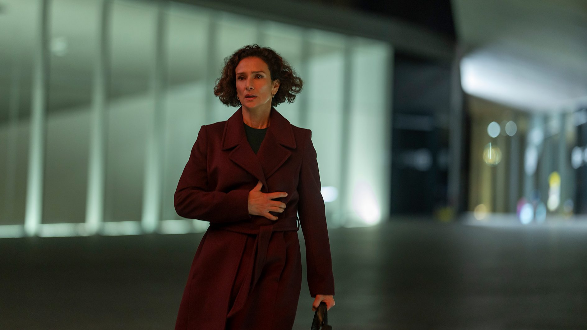 Indira Varma as Mayra Cavendish looking stressed walking through an office