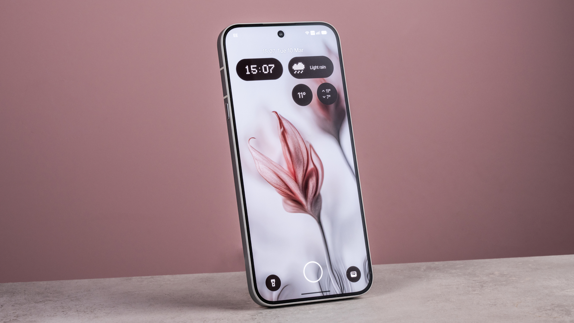 The Nothing Phone (4a) Pro's home screen features an artificial image of flowers, set against a pink background.