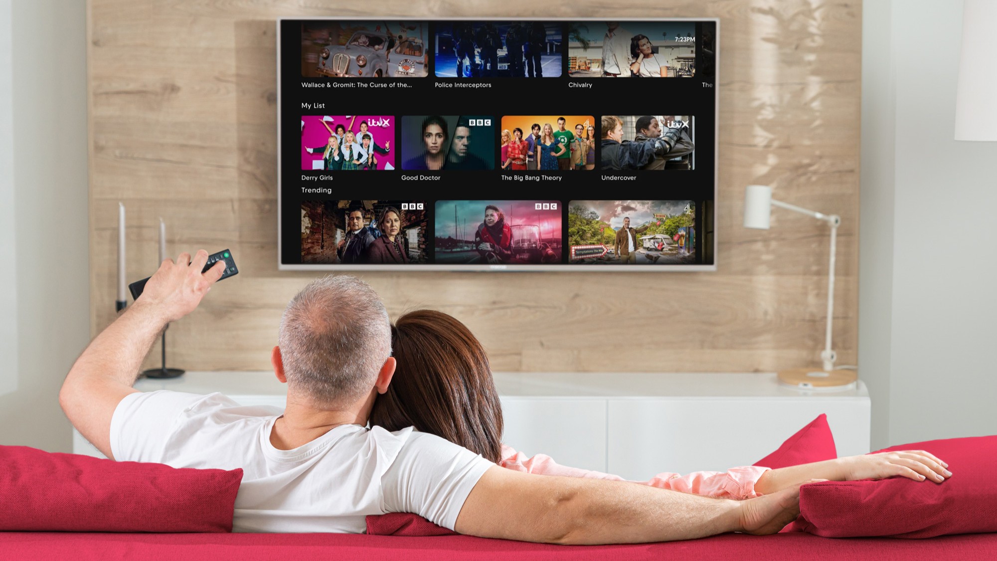 A couple sitting on a couch checking their list on Freely