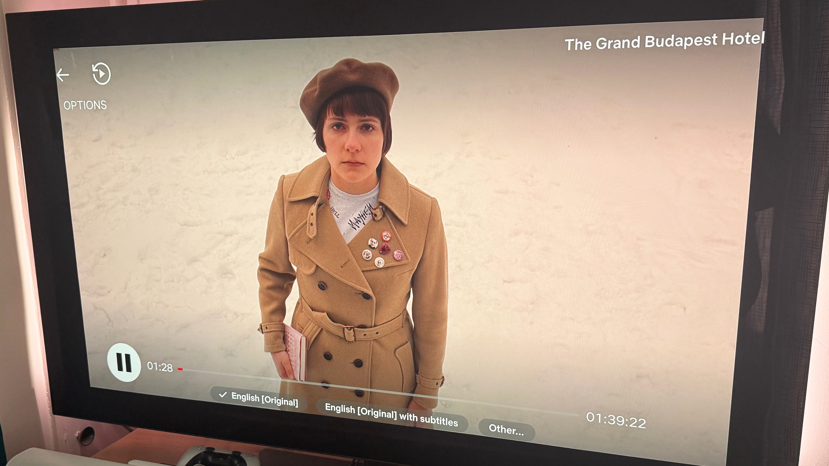 An image of the Grand Budapest Hotel, showing a character on a snowy terrain. Netflix's new interface is superimposed on the image