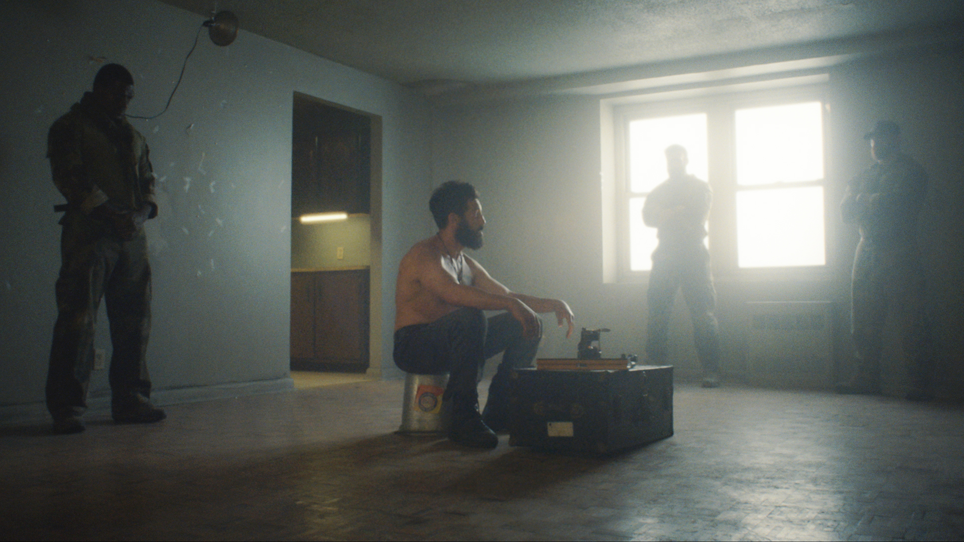 A half-naked Frank Castle sits in a room with three men looking at him in The Punisher: One Last Kill