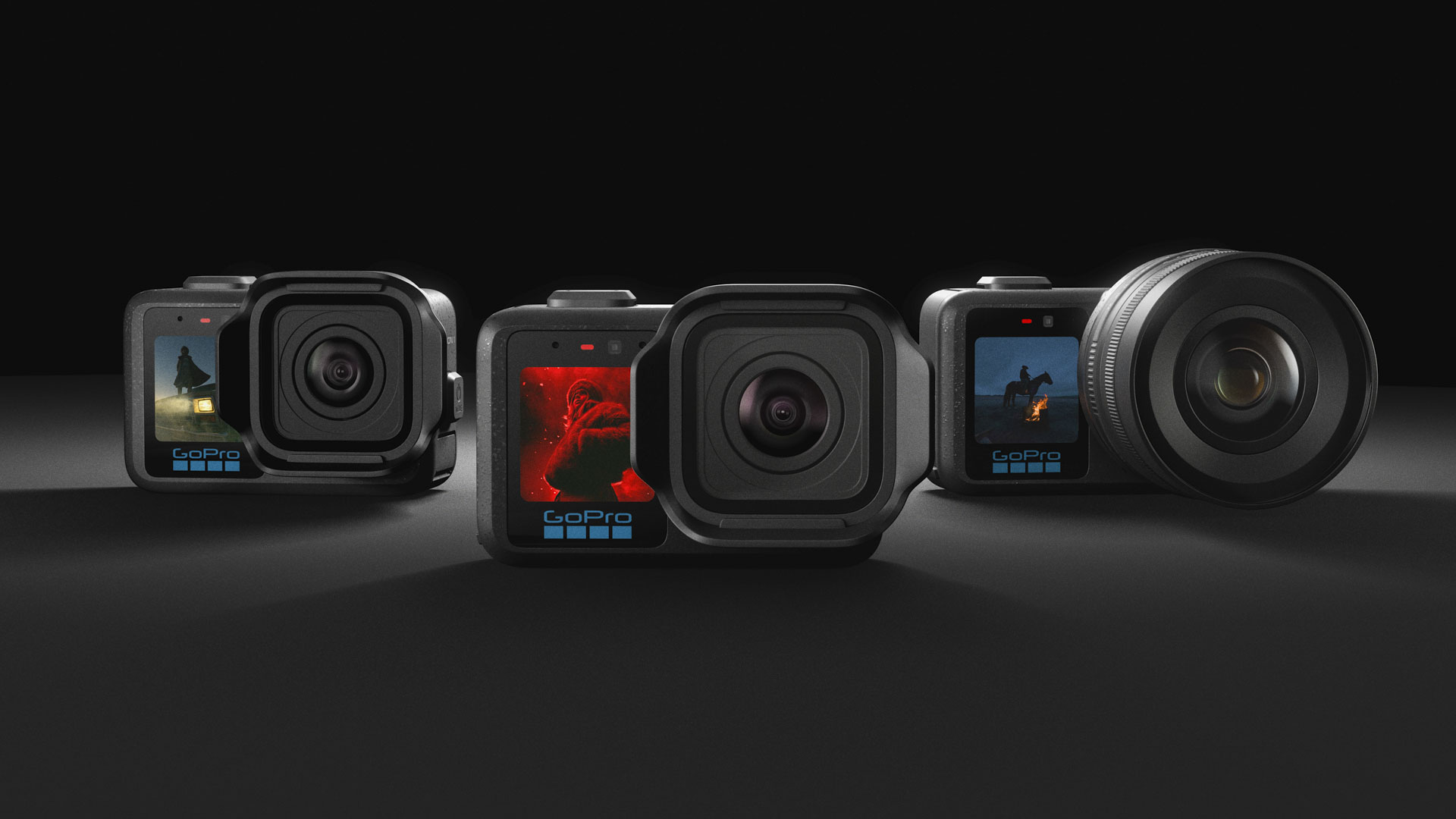 The three GoPro Mission 1 series action cameras side by side on a dark studio background.