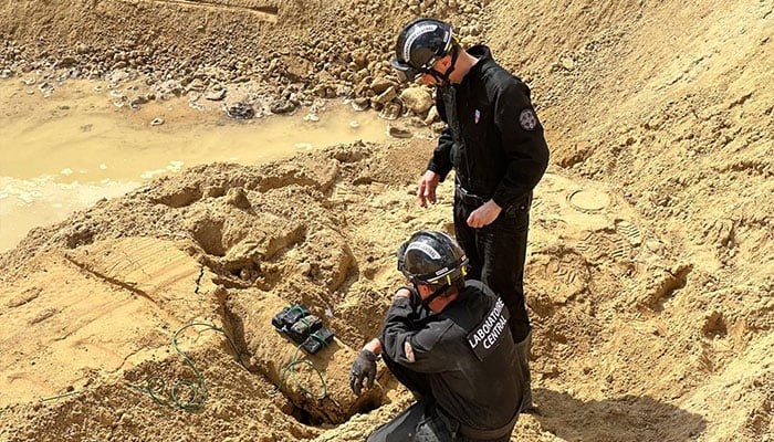 This undated photo provided by the Prefecture of Police on April 19, 2026 shows members of the police Explosive Ordnance Disposal (EOD) unit operating to neutralize a World War II bomb partially discovered near a residential area, in the suburb of Colombes, northwest of Paris. — AFP