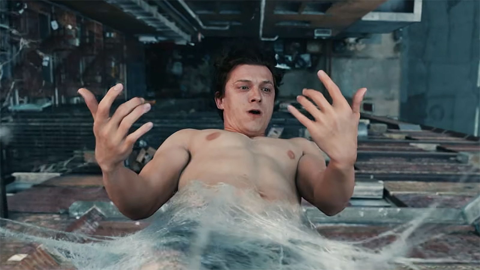 A surprised Peter Parker looking at his hands while hanging upside down in a web in Spider-Man: Brand New Day