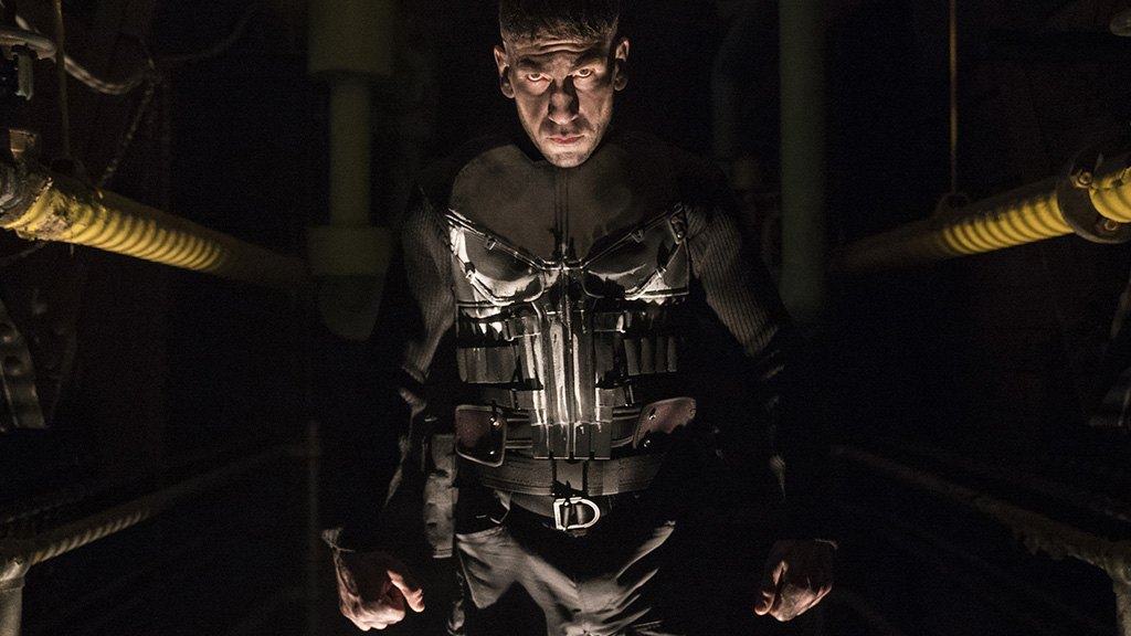 Jon Bernthal's Punisher emerges from the shadows in the comic book character's iconic costume, complete with a spray-painted skull on the front.