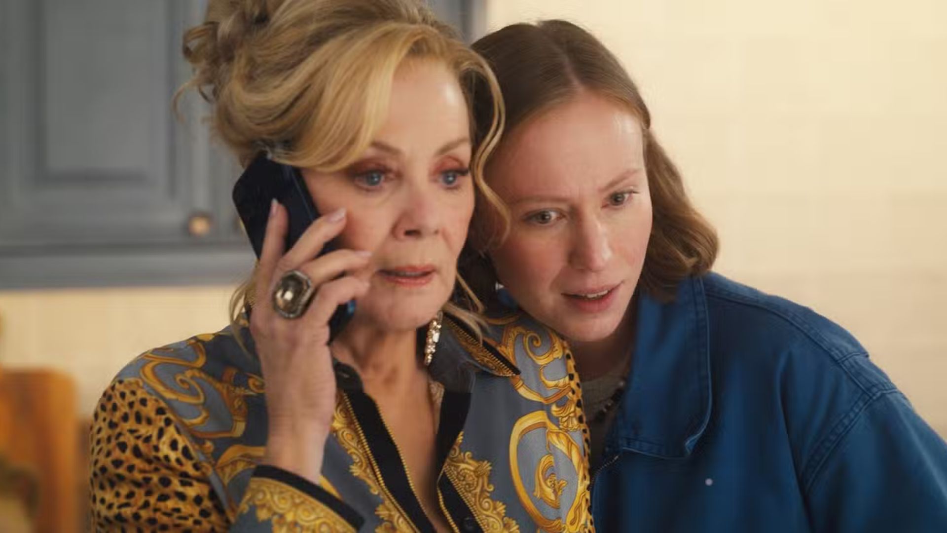 Ava leans into Deborah while talking on the phone