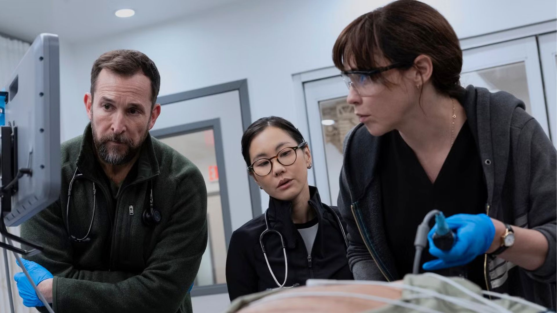 A team of doctors performs surgery on a torso.