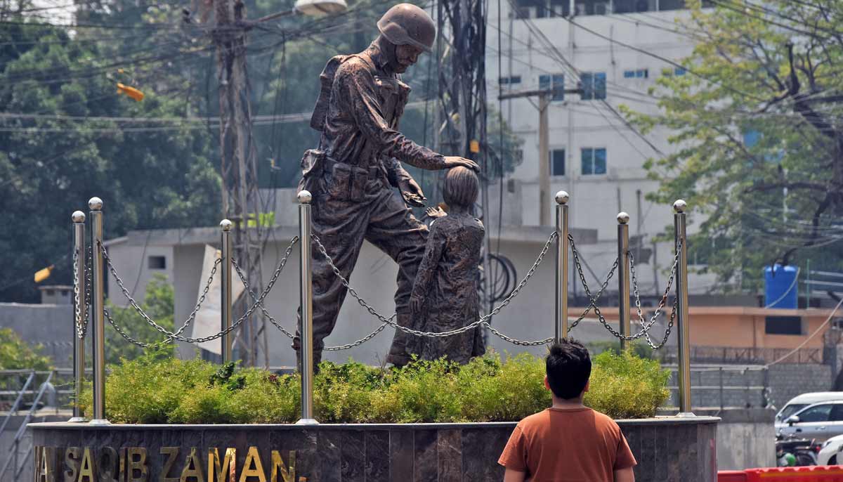 A young man looking at a sculpture of an army soldier displayed at the roundabout in the city's Panj Sarki area as Pakistan commemorates the first anniversary of Operation Bunyan-un-Marsoos. - Online