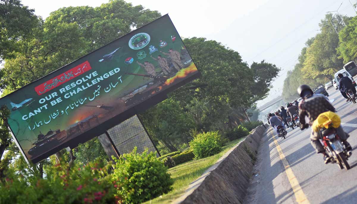 Commuters walk past a digital roadside billboard on a green belt along the Islamabad Expressway in the federal capital as Pakistan marks the first anniversary of Operation Bunyan-un-Marsoos – Online