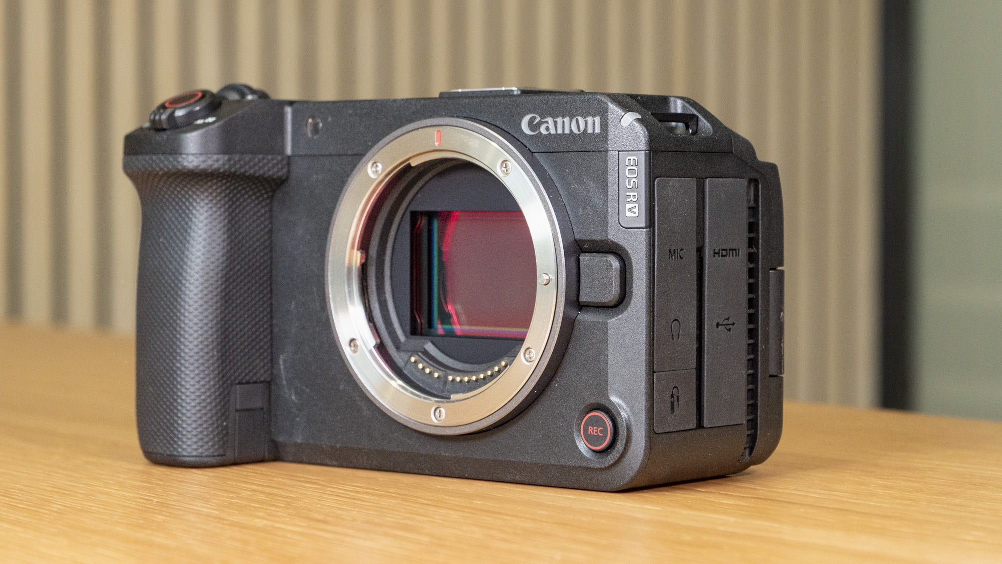 Canon EOS R6 V mirrorless camera on a wooden table with a pine slat background, without lens