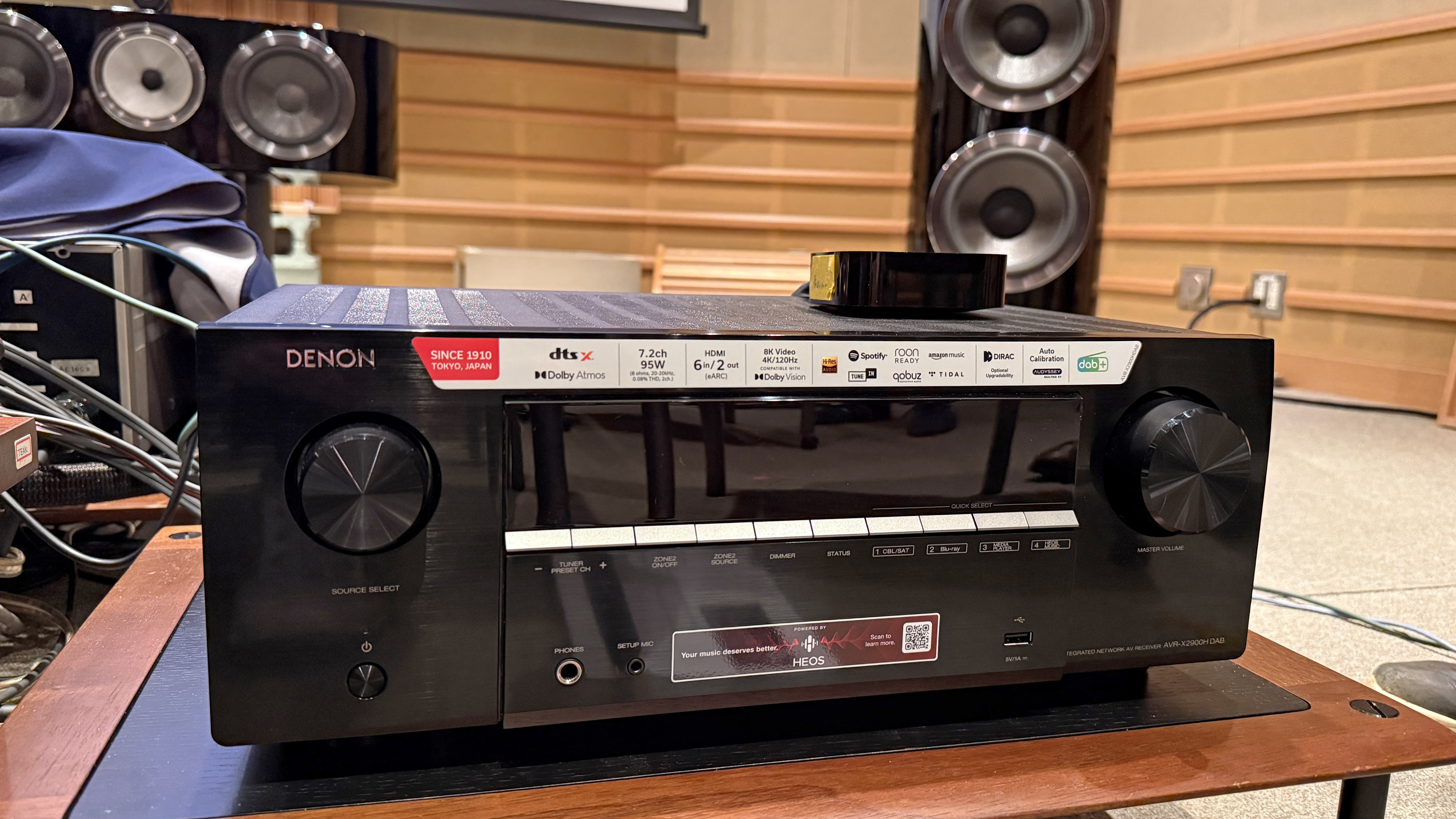 The Denon AVR-X2900H with Bowers & The Wilkins speaker is barely visible behind him. It's a black box with some dials and buttons on the front.