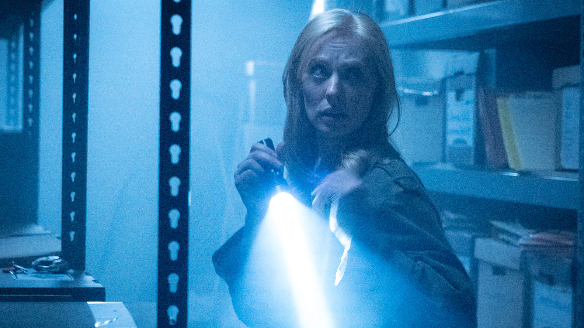 Karen Page in a dark warehouse with her torch lit in Daredevil: Born Again season 2