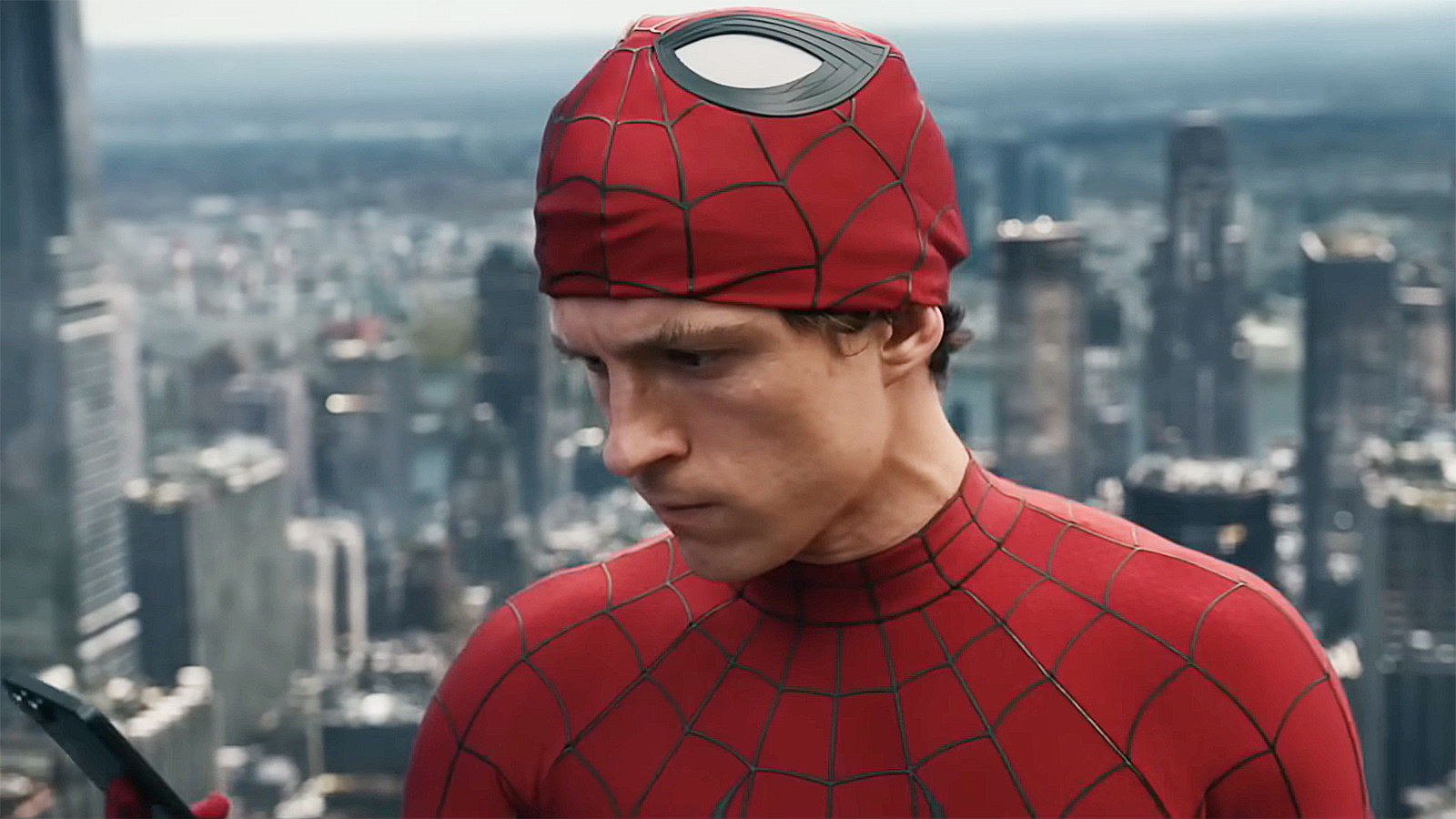 Peter Parker looking at his cell phone with his Spider-Man mask on his head in Spider-Man: Brand New Day