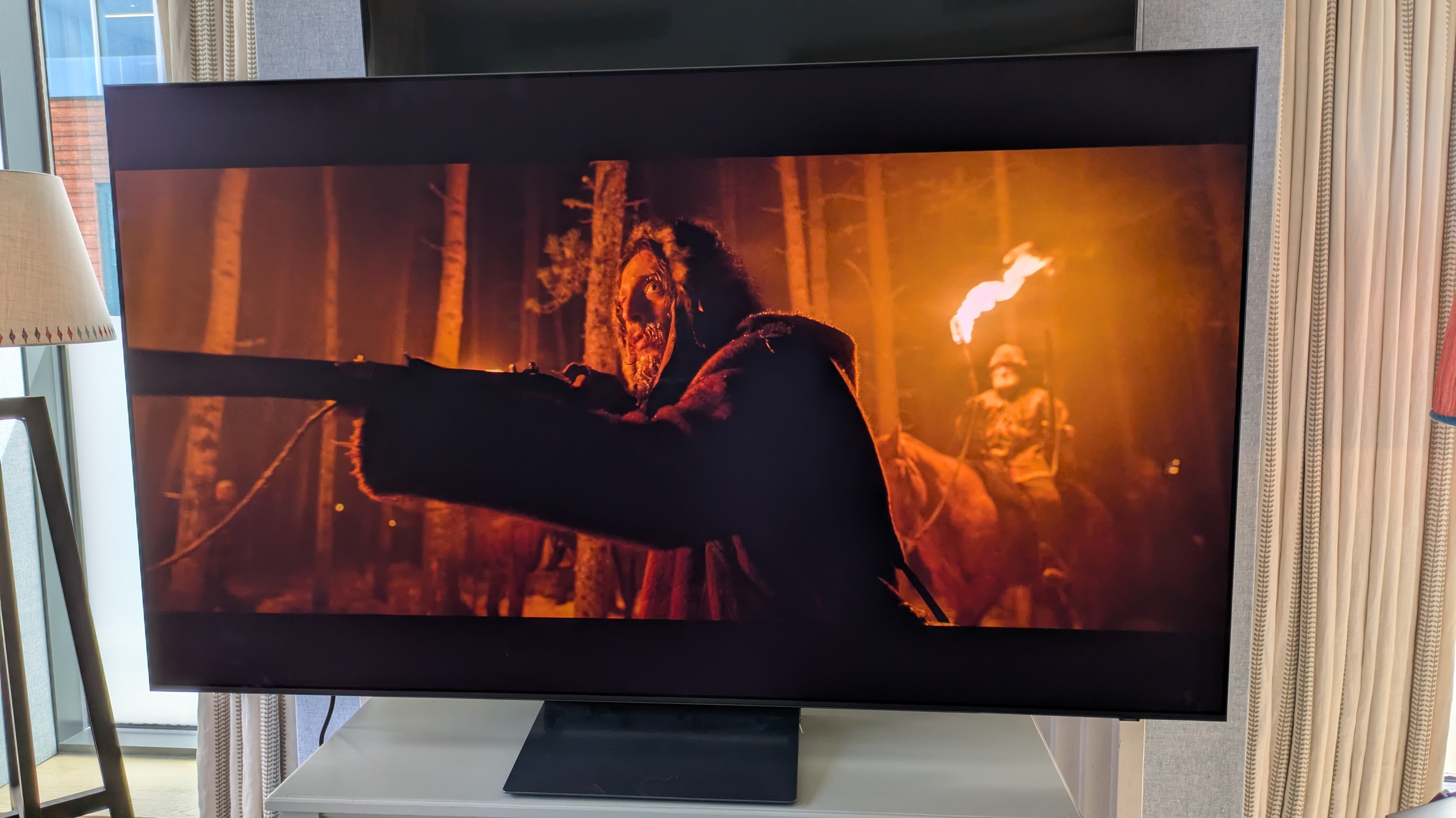 Samsung S90H OLED TV with a man holding a gun from The Revenant on the screen