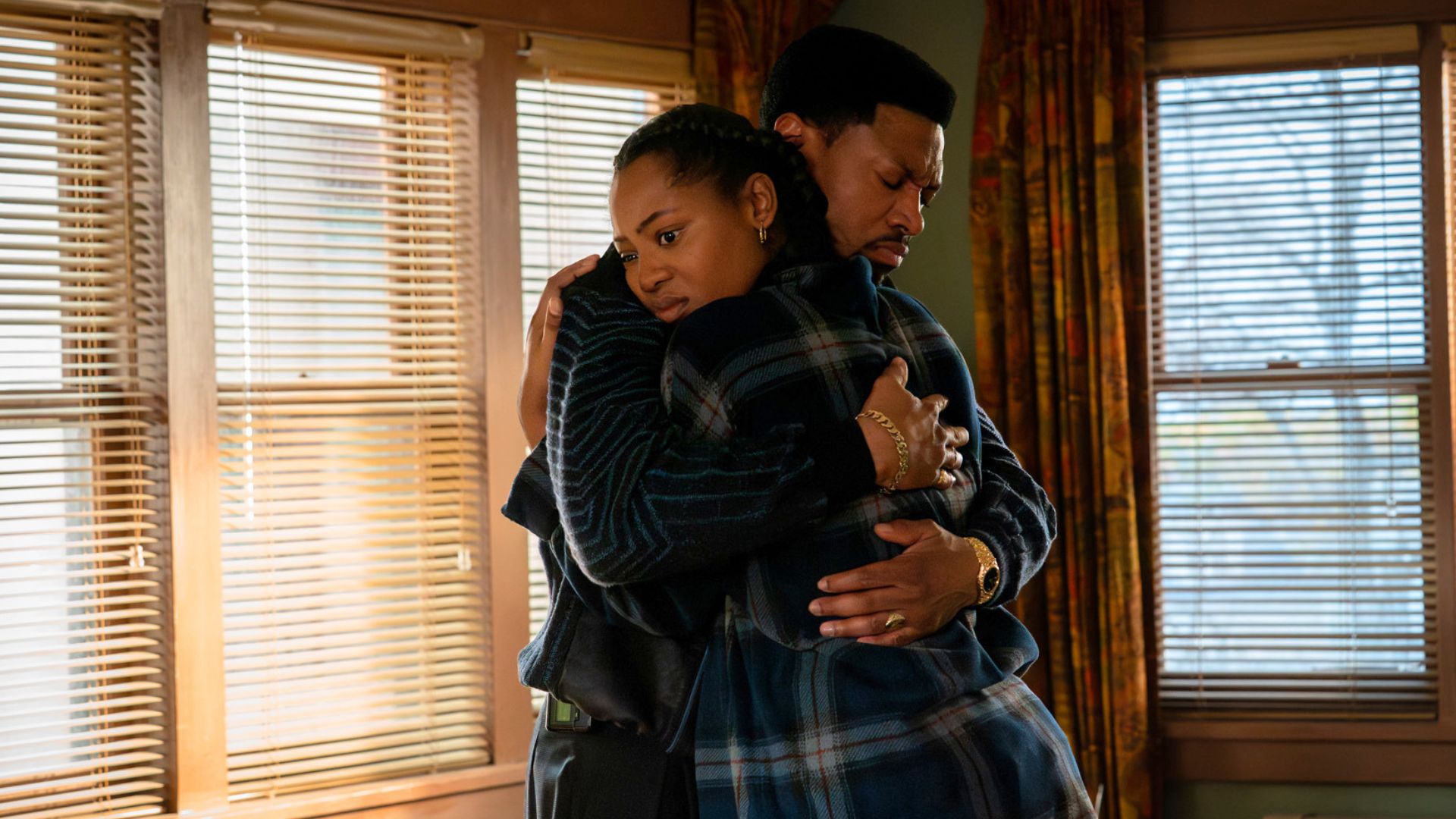 A man and a woman hug each other in an empty room.