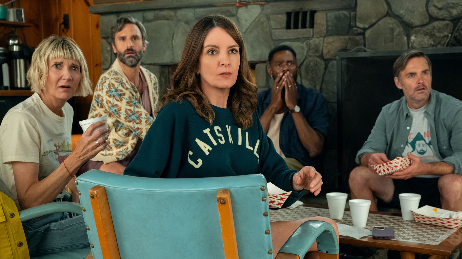 The cast of The Four Seasons seems surprised by something across the room.