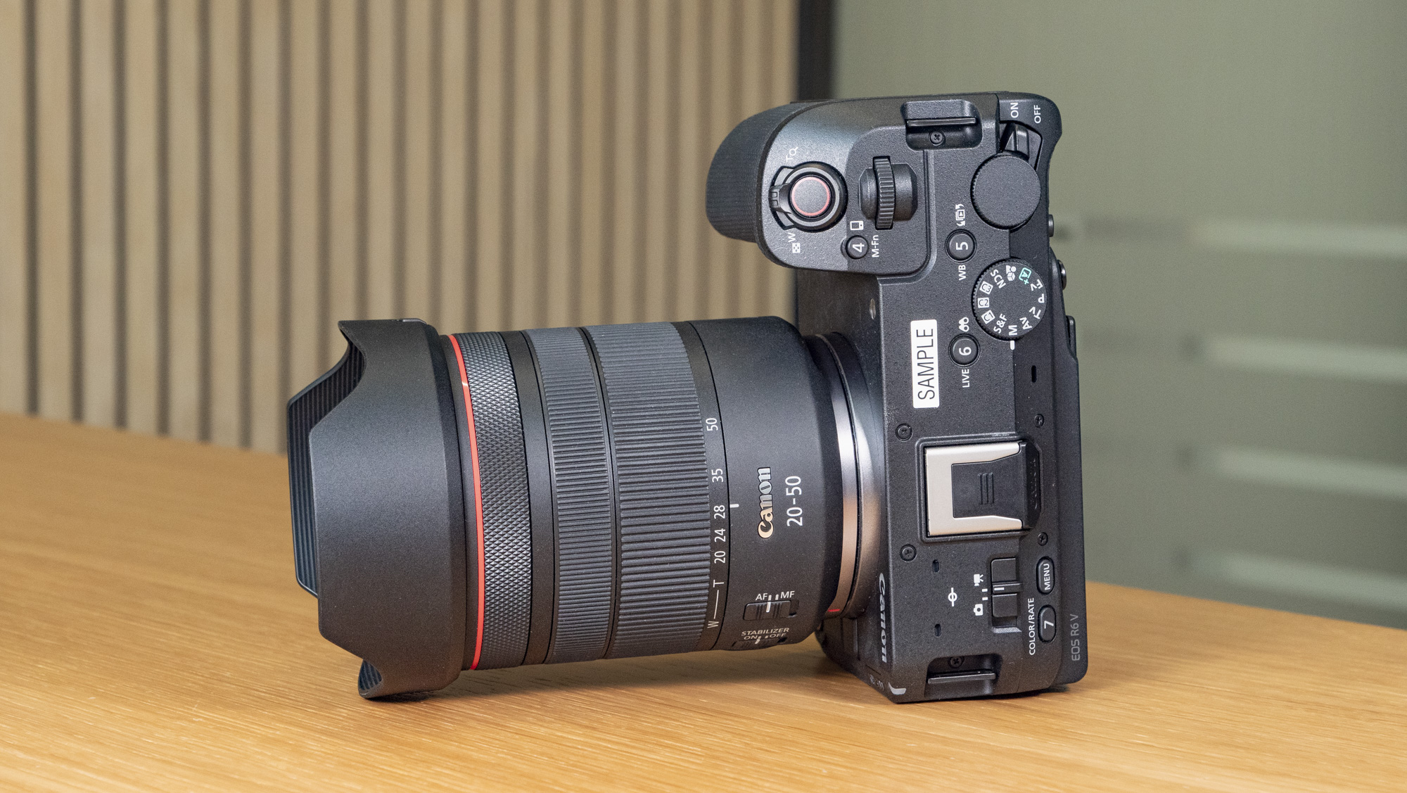 Canon EOS R6 V mirrorless camera on a wooden table with a pine slat background, without lens