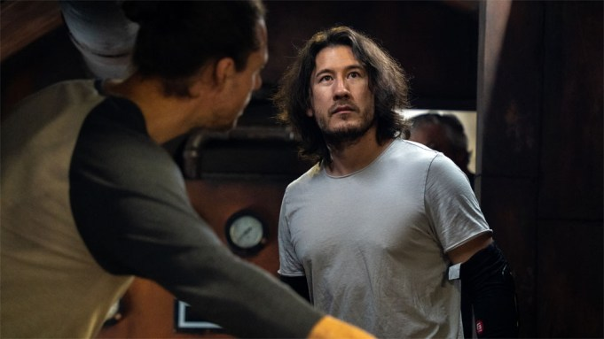 Markiplier in Iron Lung, with another man in front showing him something