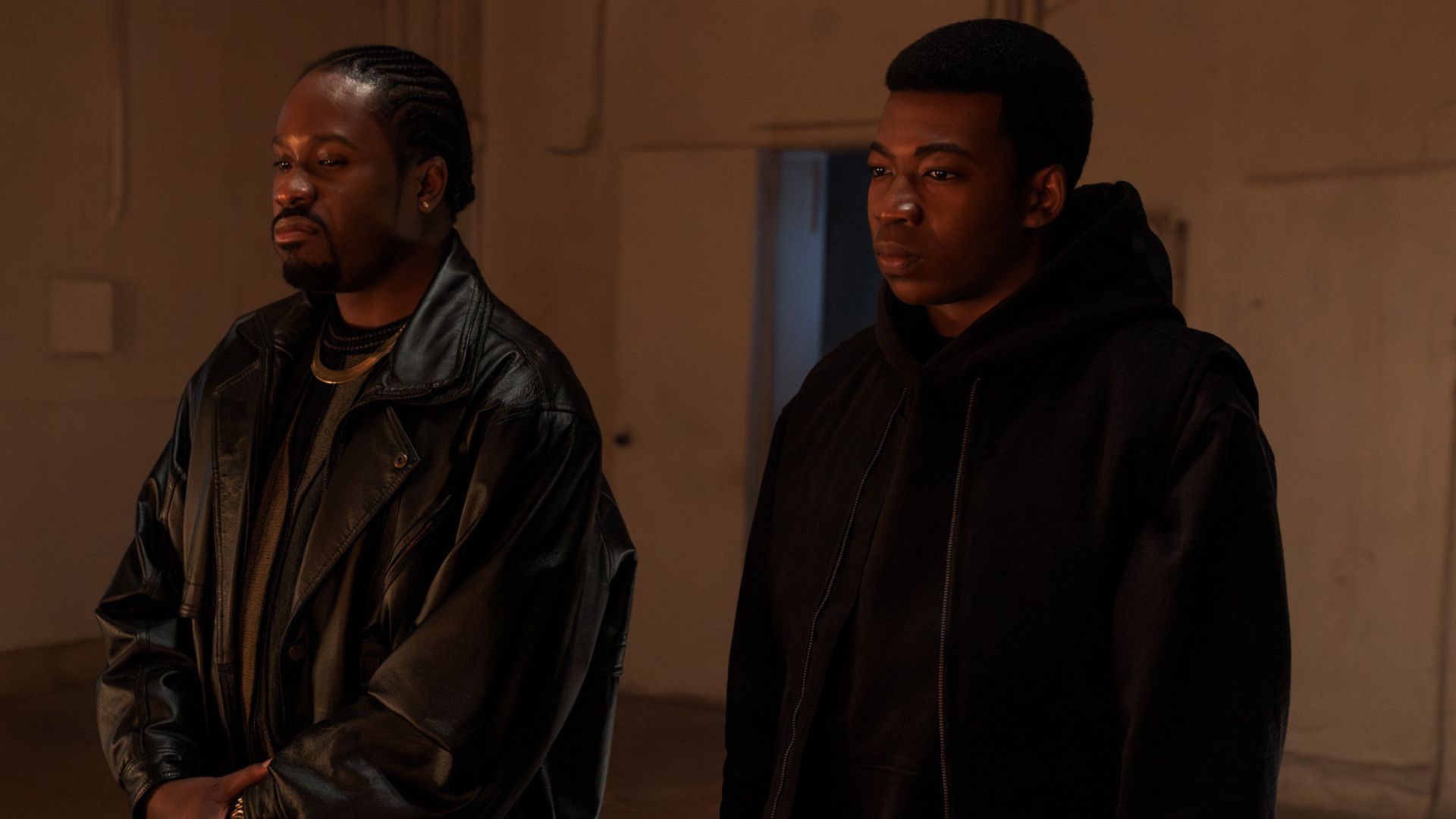 Two men look at something off-screen.