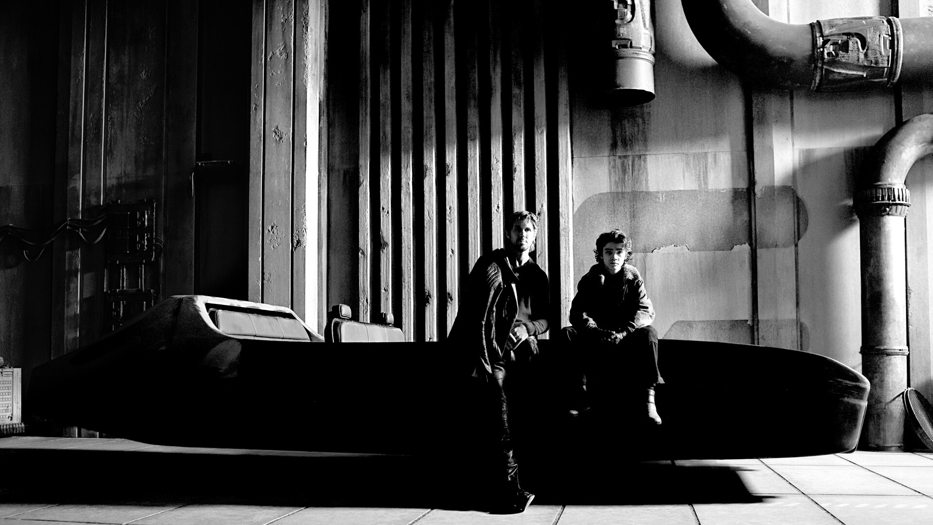 A monochrome behind-the-scenes image of Ryan Gosling and Flynn Gray sitting on a speeder bike for Star Wars: Starfighter