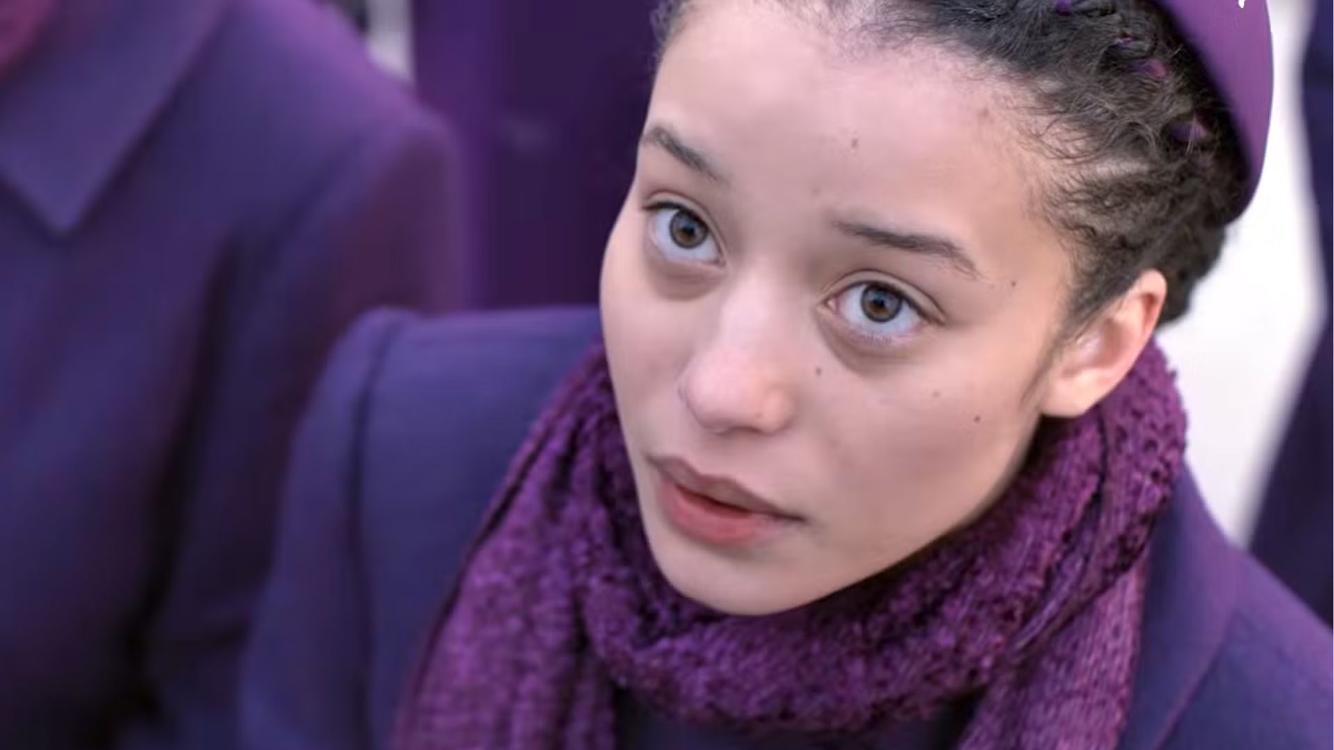 Agnes looks at something off screen.