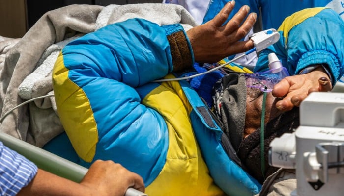 Mountaineer Dawa Sherpa is carried by doctors and rescuers upon arrival at HAMS hospital in Kathmandu on June 4, 2026. — AFP