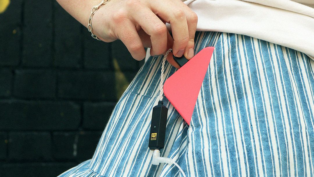 iFi Go Link 2 Max coming out of a woman's pocket, with a phone attached