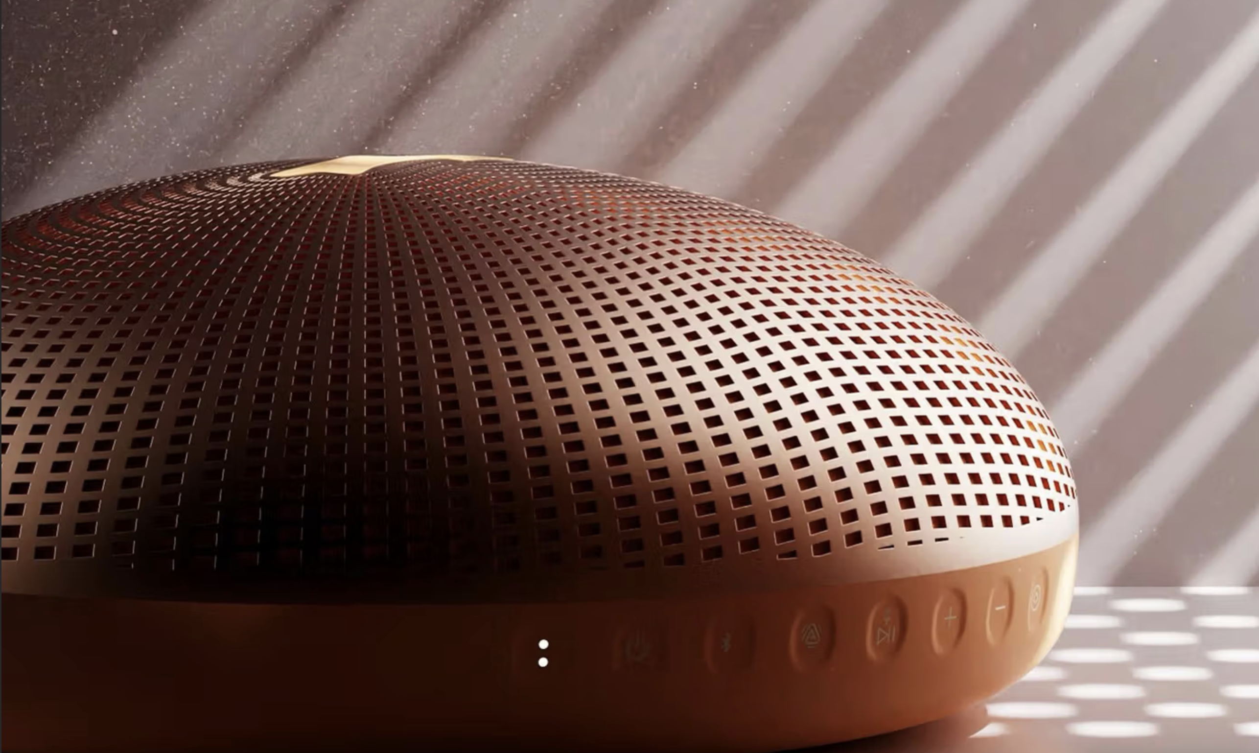 A Justin Bieber speaker in orange, showing some buttons on the side, with ambient lighting.