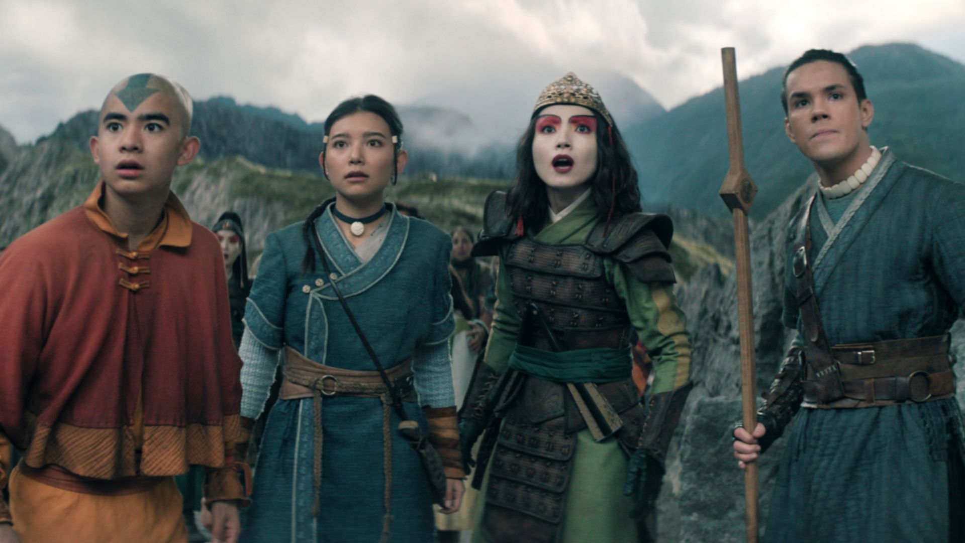 Aang and his friends stand in front of a mountain.