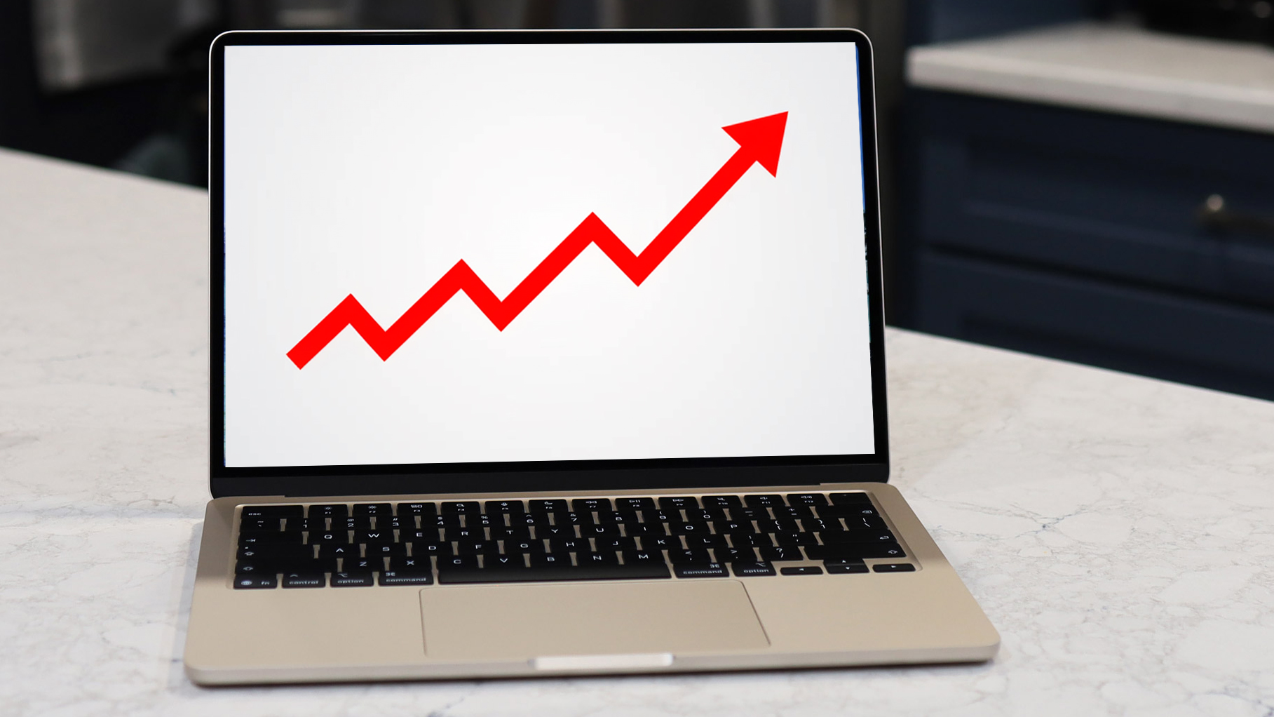 A MacBook screen showing a red ascending arrow