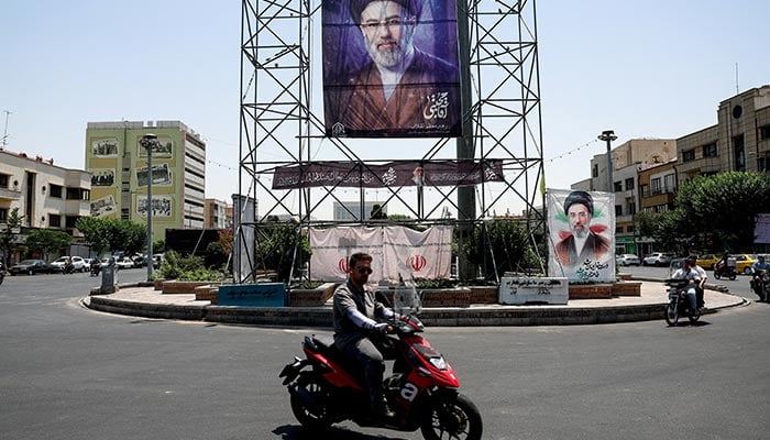 People walk past a banner with an image of Iran's Supreme Leader Mojtaba Khamenei in Tehran, Iran, June 28, 2026. – Reuters