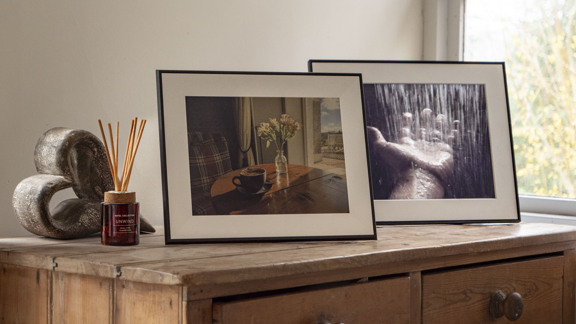 The Aura Ink 'E Ink' digital photo frame on a sideboard, next to the Aura Walden frame